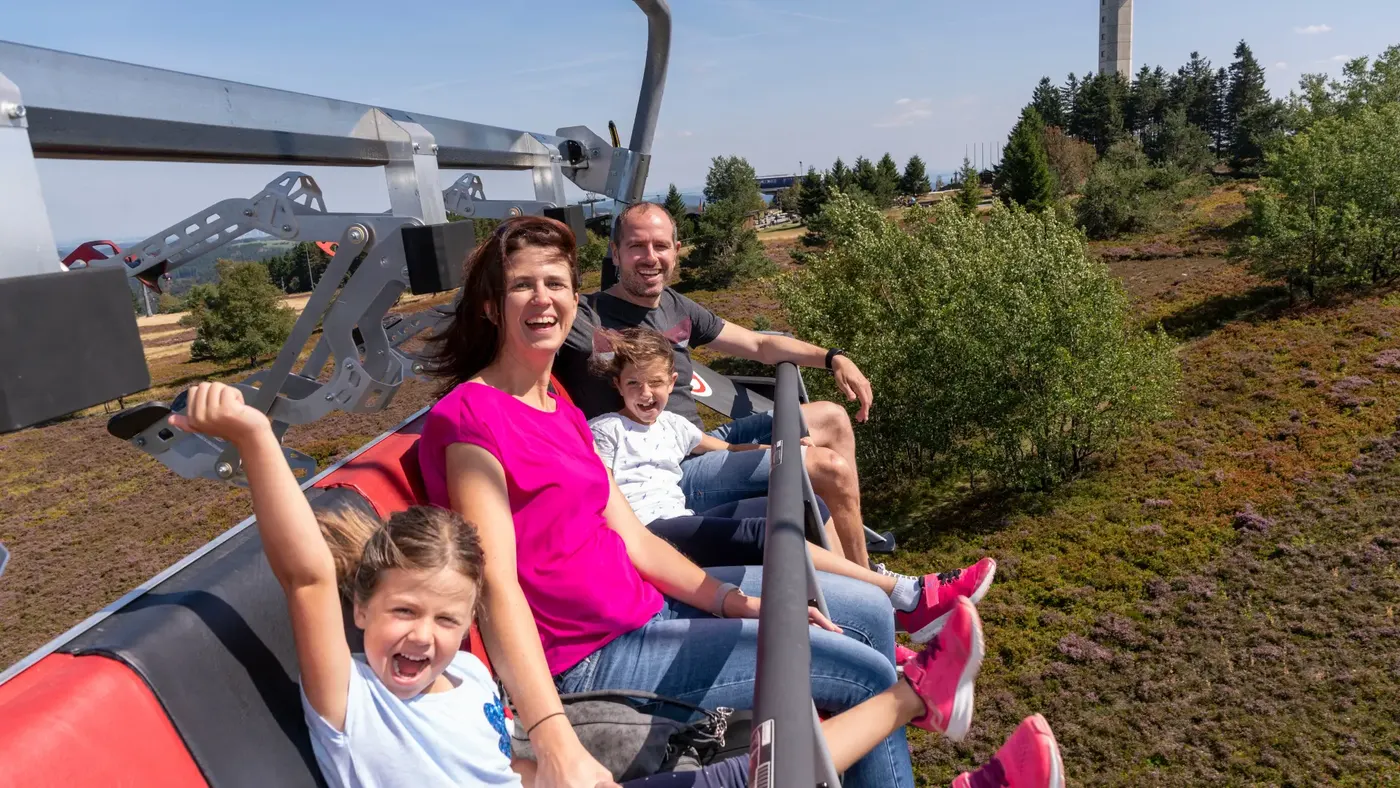 Familie fährt lachend mit dem Sessellift