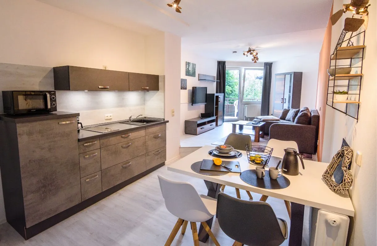 Wohnküche der Ferienwohnung Emmi mit Esstisch und Sofa