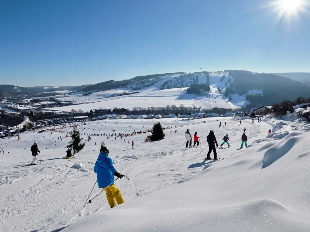 Skifahrer auf sonniger Piste in Willingen mit Blick über das verschneite Tal